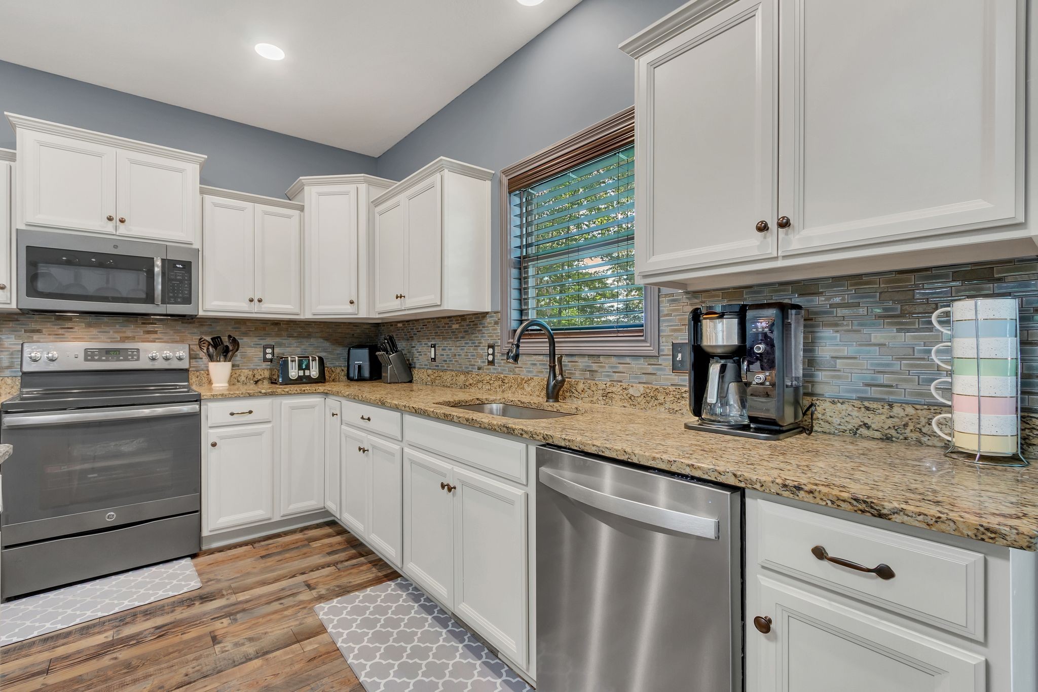1027 Garton Road Burns, TN 37029 - Photo 15 of 36 a kitchen with granite countertop a sink stainless steel appliances and cabinets