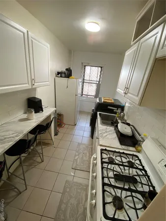 a kitchen with a stove a refrigerator and a window