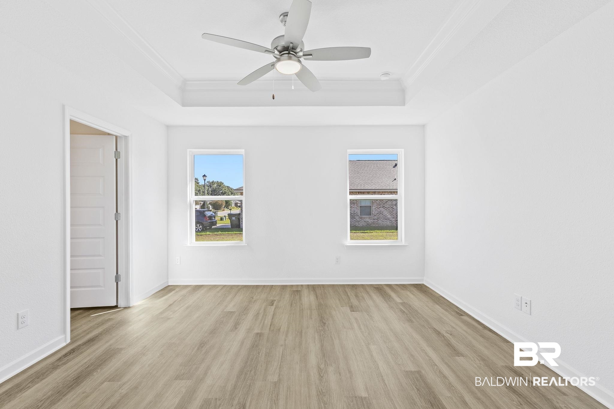 16014 Alabama Avenue Silverhill, AL 36576 - Photo 19 of 50 Empty room with a raised ceiling, ornamental molding, light hardwood / wood-style flooring, and ceiling fan