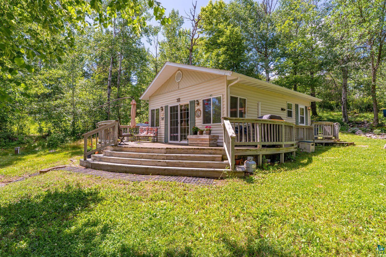3609 Fectos Road Tower, MN 55790 - Photo 2 of 24 Back of property featuring a wooden deck, a lawn, and view of scattered trees