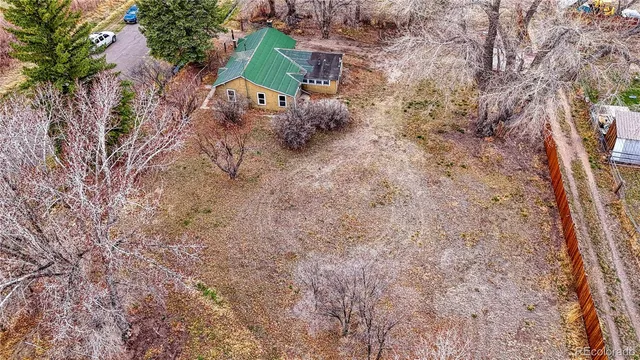 an aerial view of a house with a yard and large tree