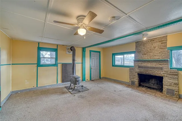 a view of an empty room with a fireplace and a window