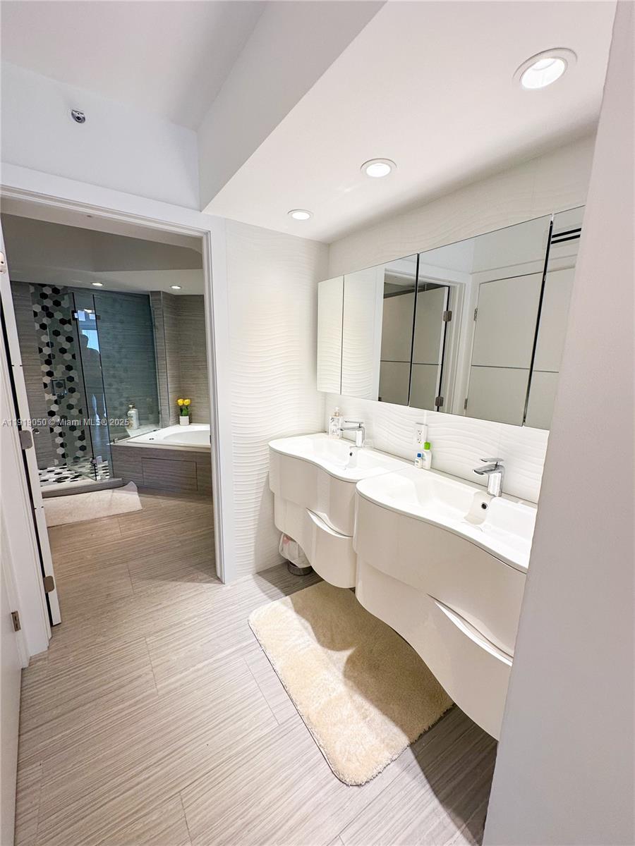 6301 Collins Avenue, Unit 2707 Miami Beach, FL 33141 - Photo 14 of 38 a bathroom with a double vanity sink mirror and bathtub