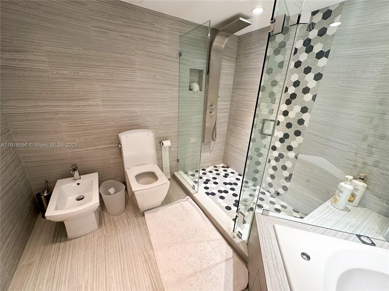 6301 Collins Avenue, Unit 2707 Miami Beach, FL 33141 - Photo 17 of 38 a bathroom with a toilet and a shower curtain