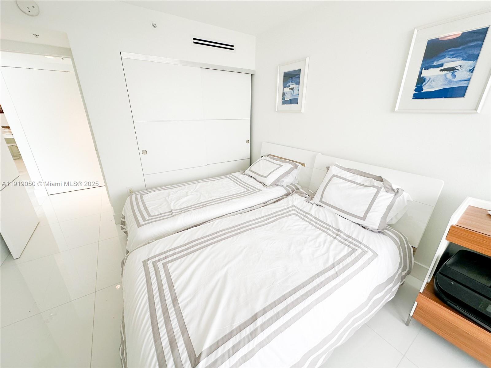 6301 Collins Avenue, Unit 2707 Miami Beach, FL 33141 - Photo 24 of 38 a bed sitting in a bedroom next to a window