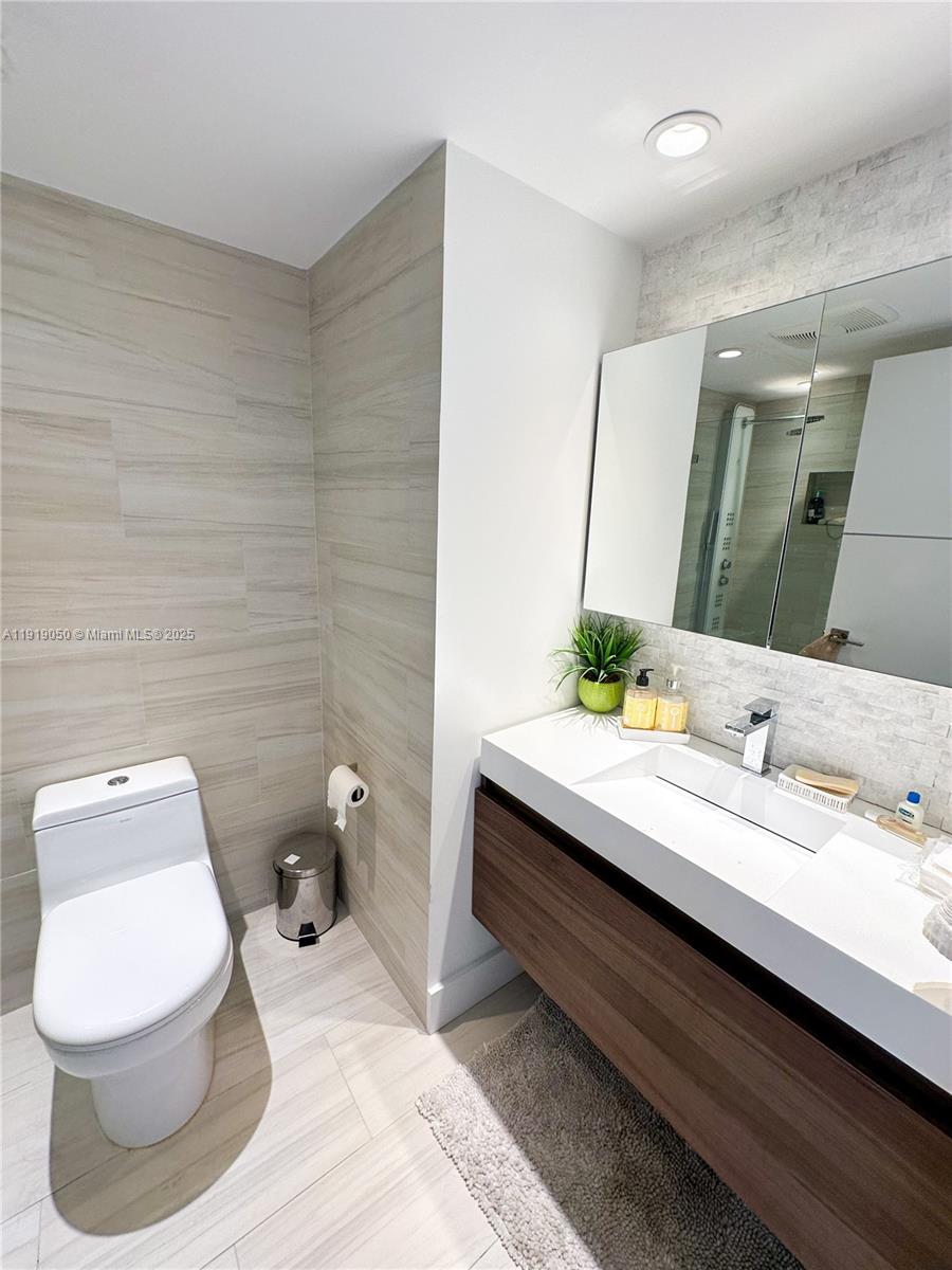 6301 Collins Avenue, Unit 2707 Miami Beach, FL 33141 - Photo 25 of 38 a bathroom with a toilet sink and mirror