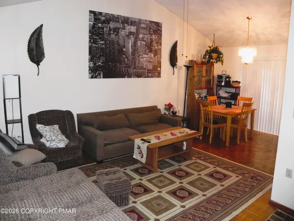 a living room with couches and work view with wooden floor