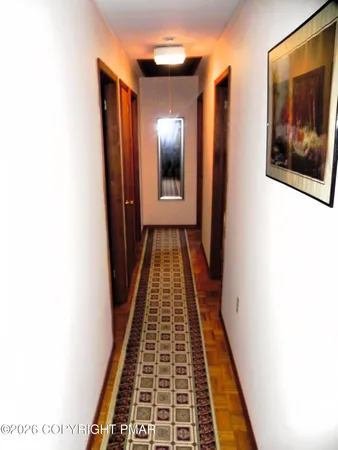 a view of a hallway with wooden floor