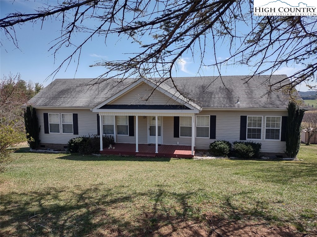 a front view of a house with a garden and trees