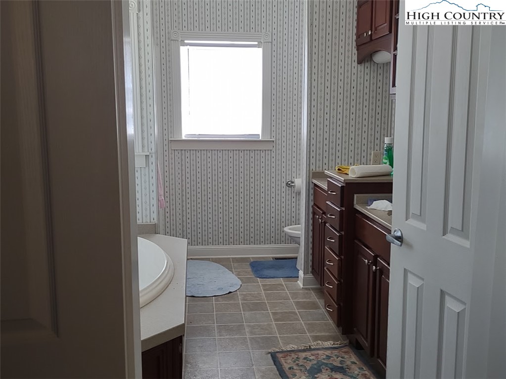 1407 Barrett Road Ennice, NC 28623 - Photo 17 of 24 a bathroom with a granite countertop toilet and a sink