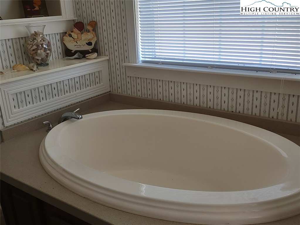 1407 Barrett Road Ennice, NC 28623 - Photo 18 of 24 a bathroom with a bathtub and a window