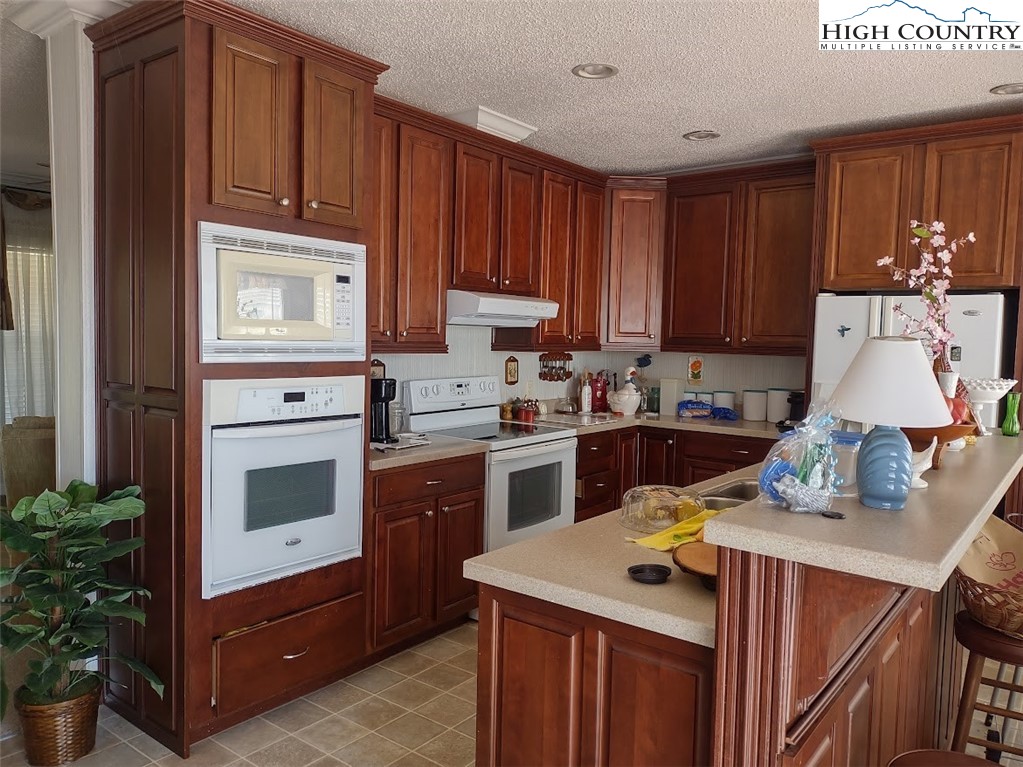 1407 Barrett Road Ennice, NC 28623 - Photo 9 of 24 a kitchen with a stove top oven sink and cabinets