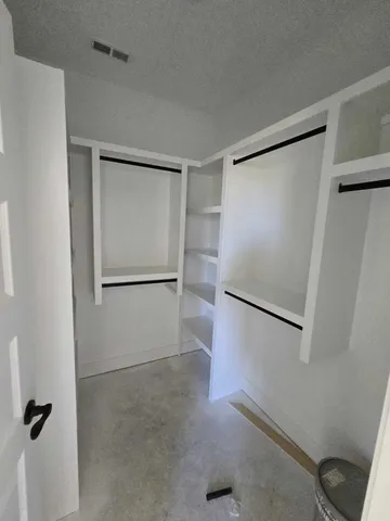 an empty room with closet and a ceiling fan