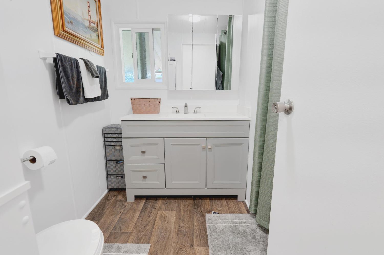 10035 Mills Station Road, Unit 153 Sacramento, CA 95827 - Photo 14 of 24 a bathroom with a sink a toilet and mirror
