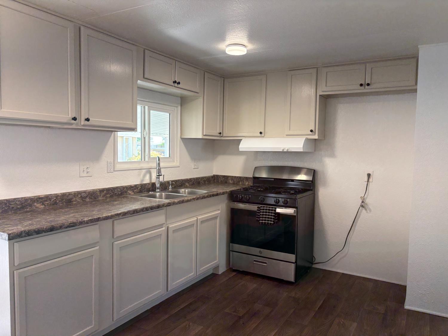 10035 Mills Station Road, Unit 153 Sacramento, CA 95827 - Photo 3 of 24 a kitchen with granite countertop a sink and a stove