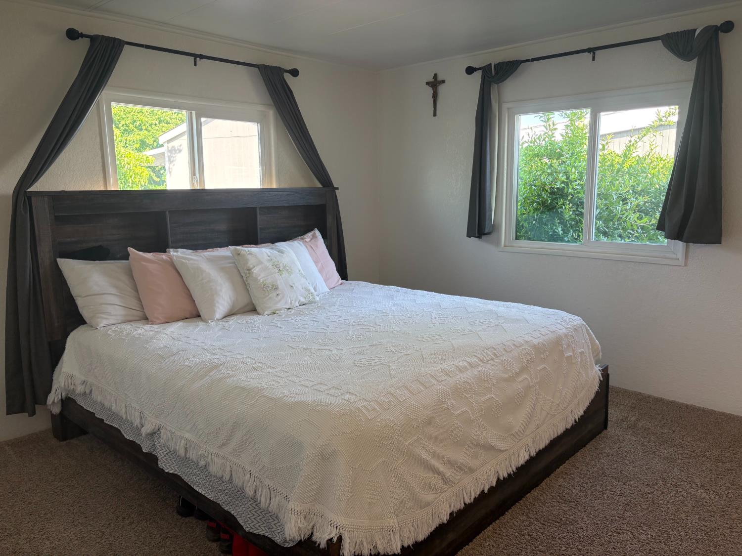 10035 Mills Station Road, Unit 153 Sacramento, CA 95827 - Photo 7 of 24 a large bed sitting in a bedroom next to a window