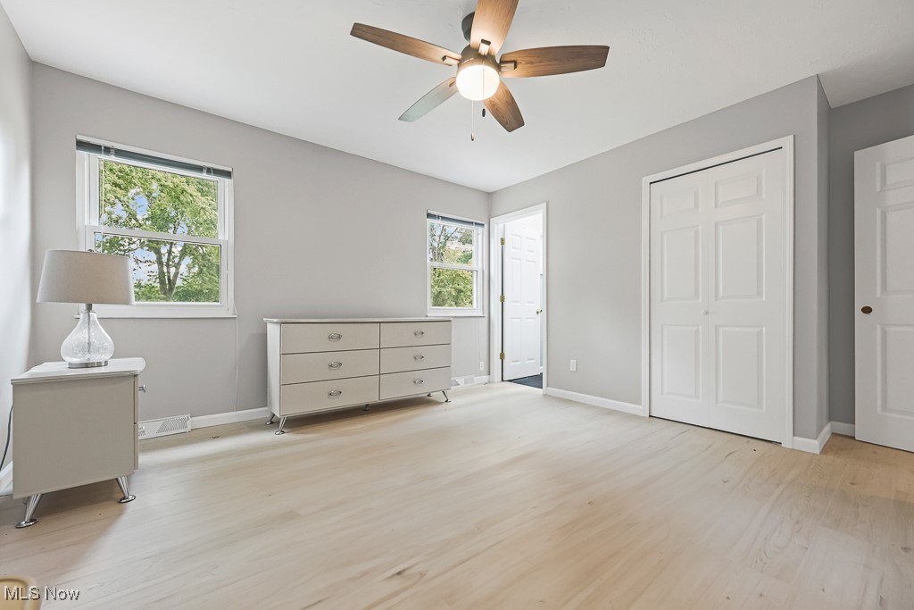 17682 Drake Road Strongsville, OH 44136 - Photo 20 of 45 Bedroom with light wood finished floors, multiple windows, a ceiling fan, and a closet