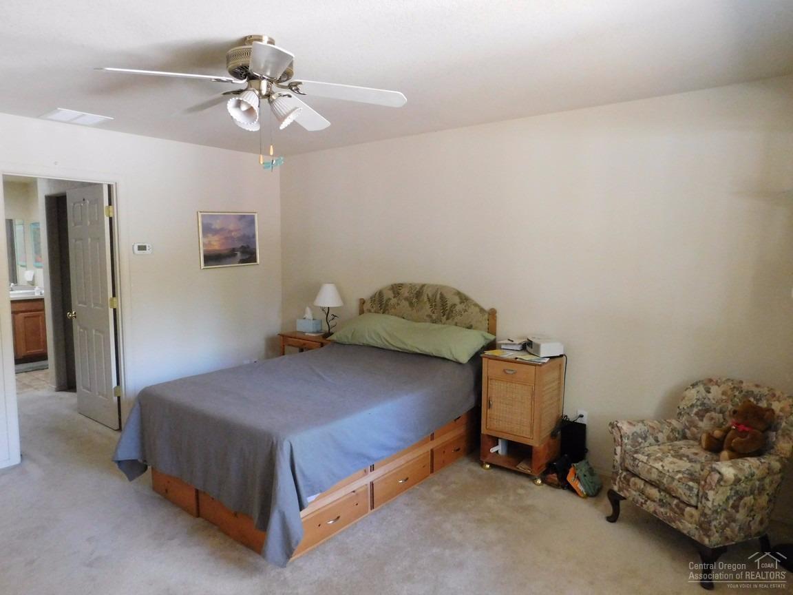 16984 Glendale Road Bend, OR 97707 - Photo 7 of 24 a bedroom with a bed and a chandelier