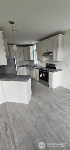 a kitchen with stainless steel appliances granite countertop a sink a stove top oven a counter space and cabinets