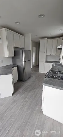 a kitchen with stainless steel appliances granite countertop a refrigerator a stove and a sink with granite countertops