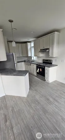 a kitchen with stainless steel appliances granite countertop a sink a stove top oven a counter space and cabinets