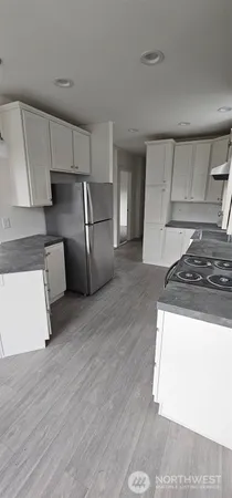 a kitchen with stainless steel appliances granite countertop a refrigerator a stove and a sink with granite countertops