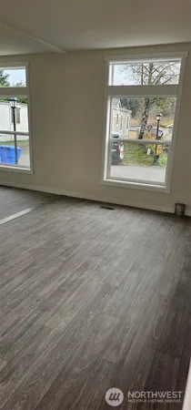 an empty room with wooden floor and a window