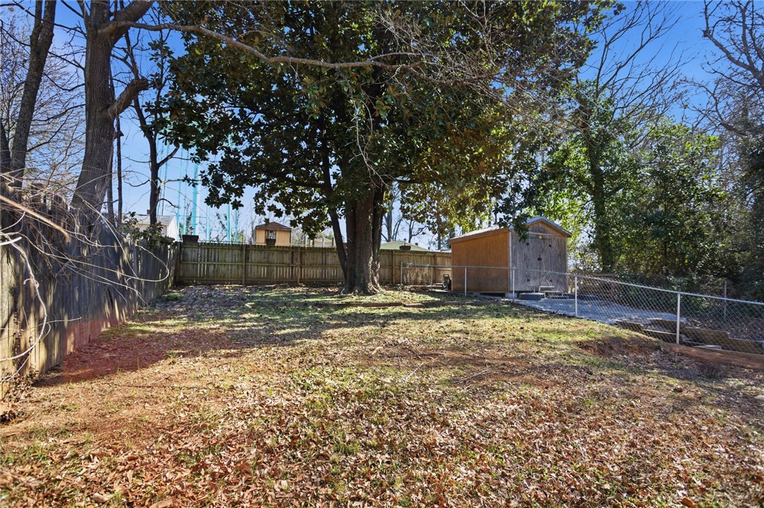 118 North 4th Street Easley, SC 29640 - Photo 14 of 14 This spacious yard features mature trees and a functional shed, offering ample outdoor potential.