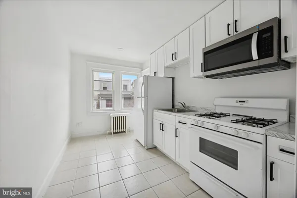 a kitchen with stainless steel appliances a stove a microwave and cabinets