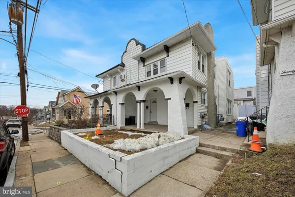 a view of a white house with many windows and yard