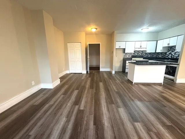 a view of kitchen with refrigerator stove and wooden floor