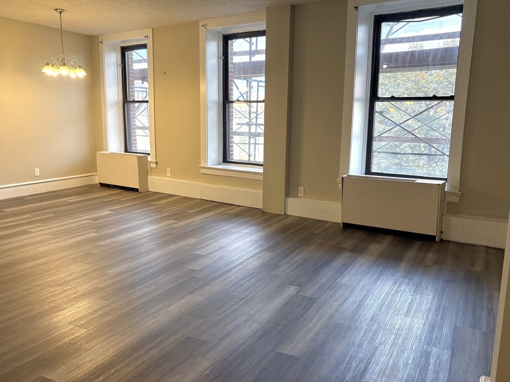 140 Chestnut Street, Unit 204 Springfield, MA 01103 - Photo 6 of 15 a view of an empty room with wooden floor and a window