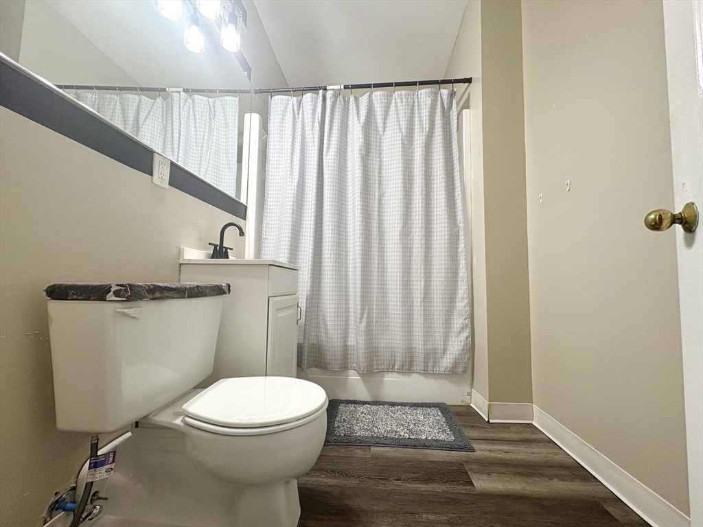 140 Chestnut Street, Unit 204 Springfield, MA 01103 - Photo 8 of 15 a bathroom with a toilet a sink and wooden floor