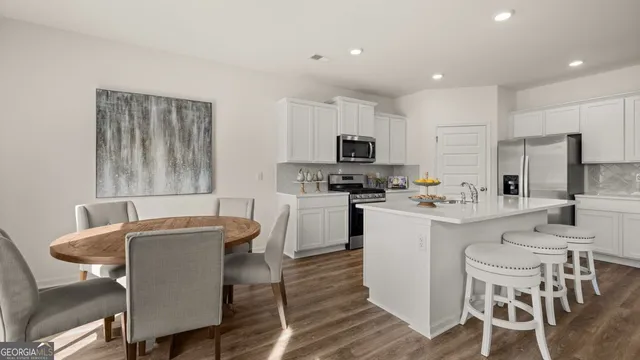 a kitchen with table chairs microwave and cabinets