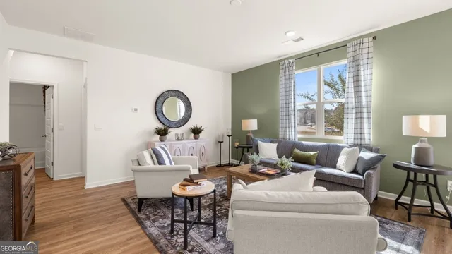 a living room with furniture a table and wooden floor