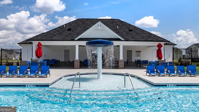 a view of a house with sitting area and yard with swimming pool