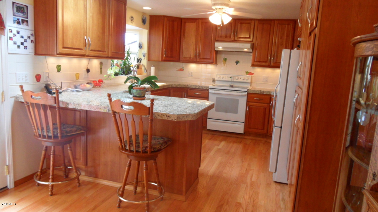 211 East Duffield Road Moxee, WA 98936 - Photo 2 of 34 a kitchen with stainless steel appliances granite countertop a refrigerator a sink dishwasher and white cabinets with wooden floor