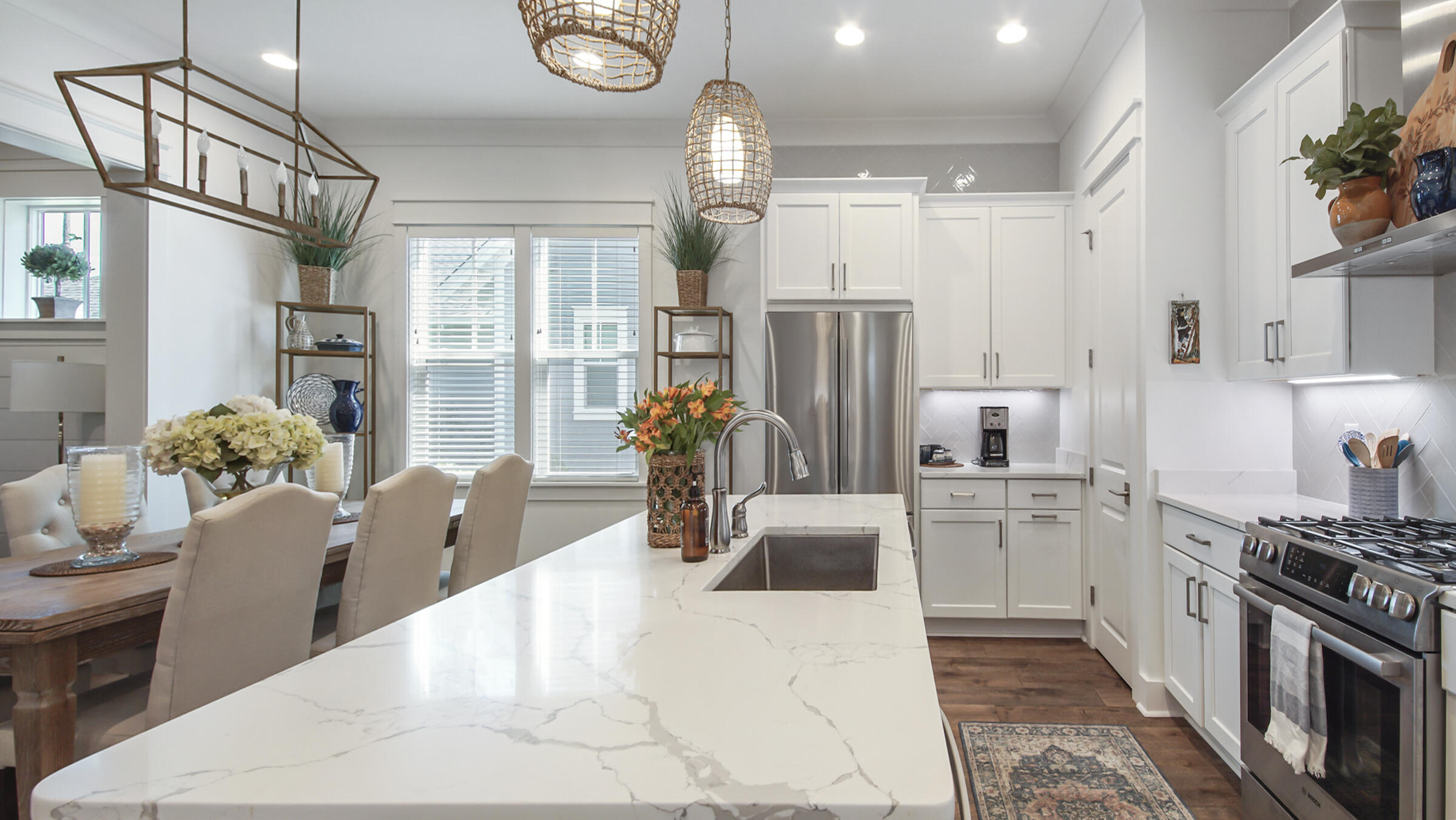 111 Firefly Way Watersound, FL 32461 - Photo 11 of 54 a kitchen with stainless steel appliances a refrigerator a stove a sink dishwasher a dining table and chairs with wooden floor