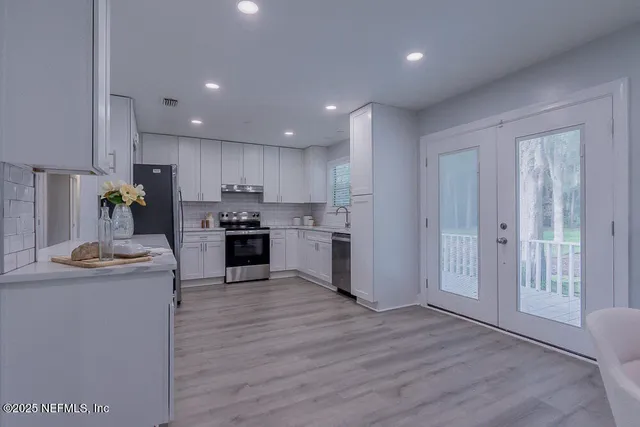 a bathroom with a toilet a sink a mirror a bathtub and vanity