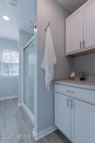 a view of a patio with table and chairs under an umbrella with wooden floor