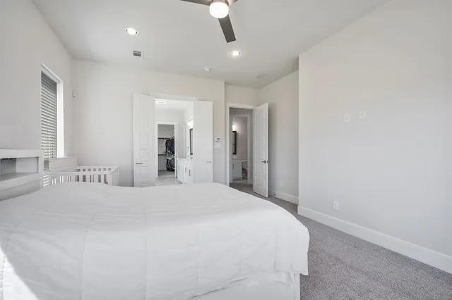 a spacious bedroom with a bed and a mirror