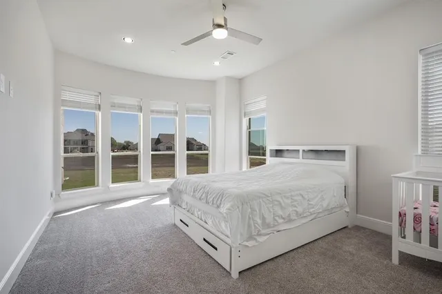a bedroom with a bed and a large window