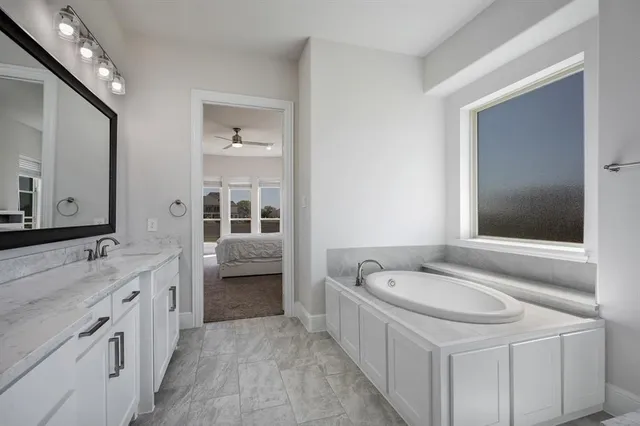 a spacious bathroom with a bathtub sink and mirror