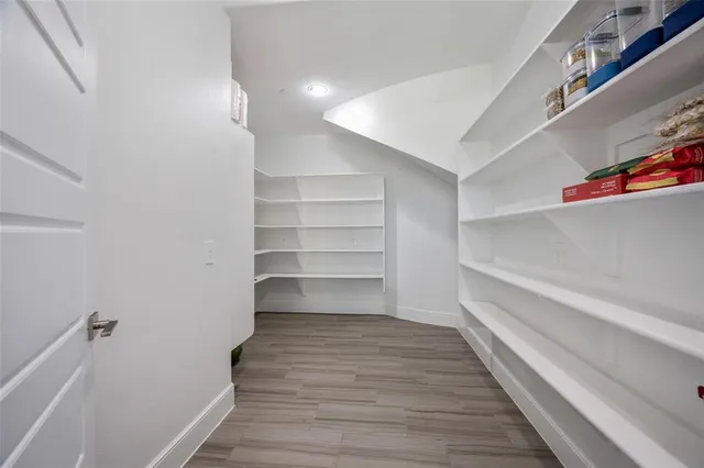 a dining room with wooden floor a chandelier a glass table and chairs
