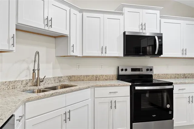 a kitchen with stainless steel appliances granite countertop a sink stove and microwave