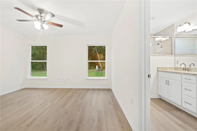 a view of room with window ceiling fan and hardwood floor