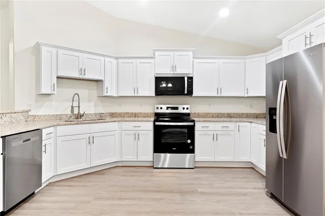 a kitchen with a refrigerator stove and sink