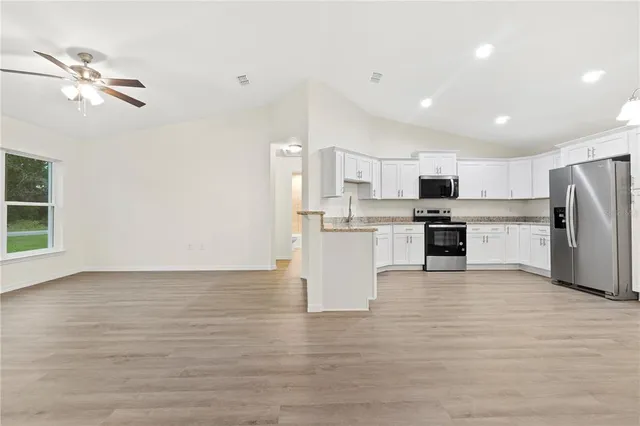 a view of kitchen with wooden floor and electronic appliances