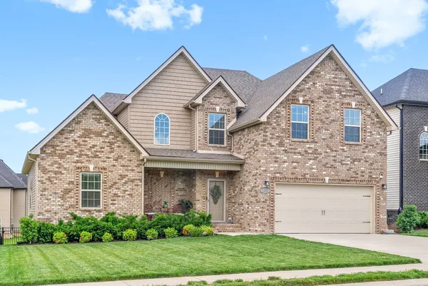 a front view of a house with a yard and garage