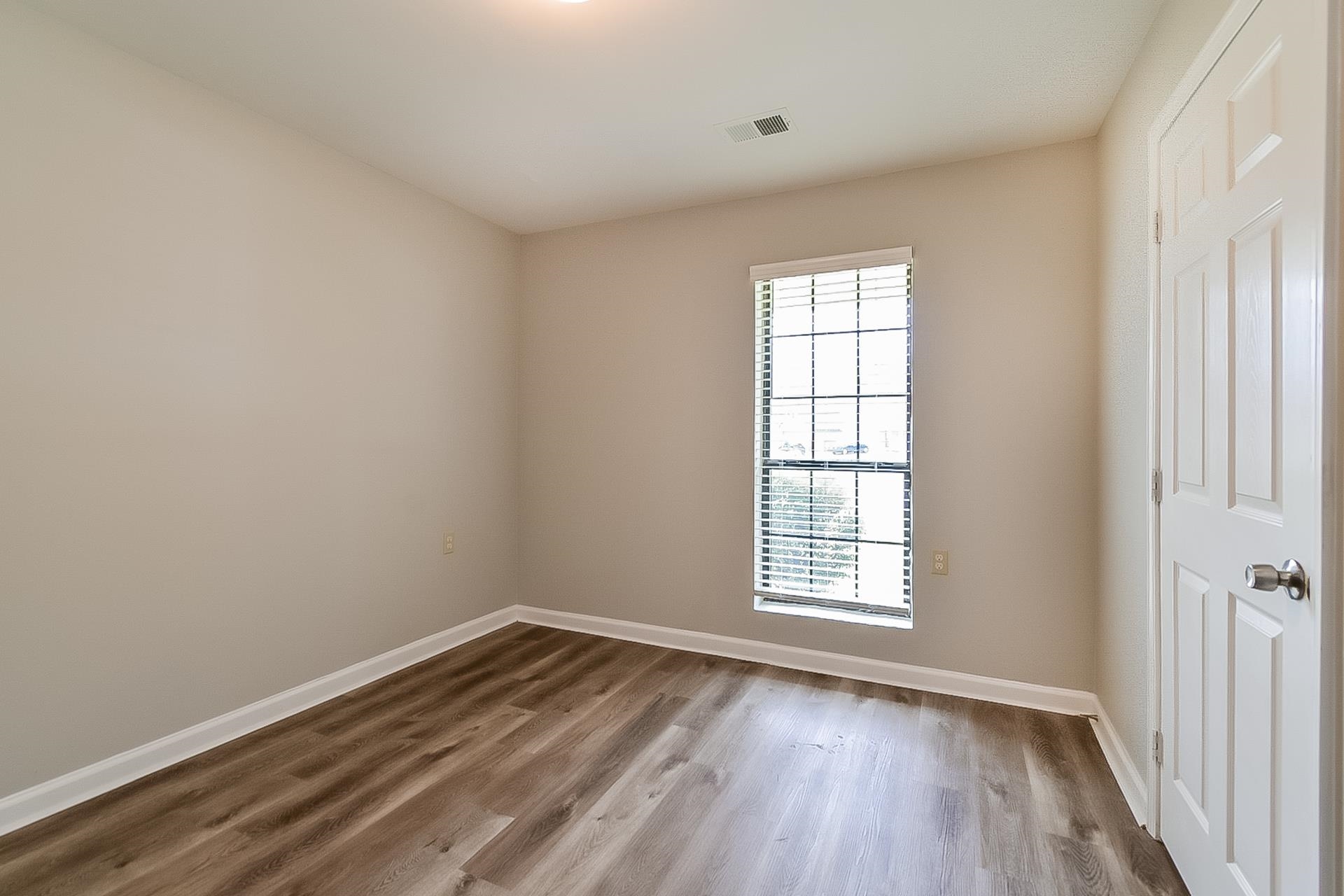 3890 Birchshade Cove Memphis, TN 38115 - Photo 11 of 16 an empty room with wooden floor and windows